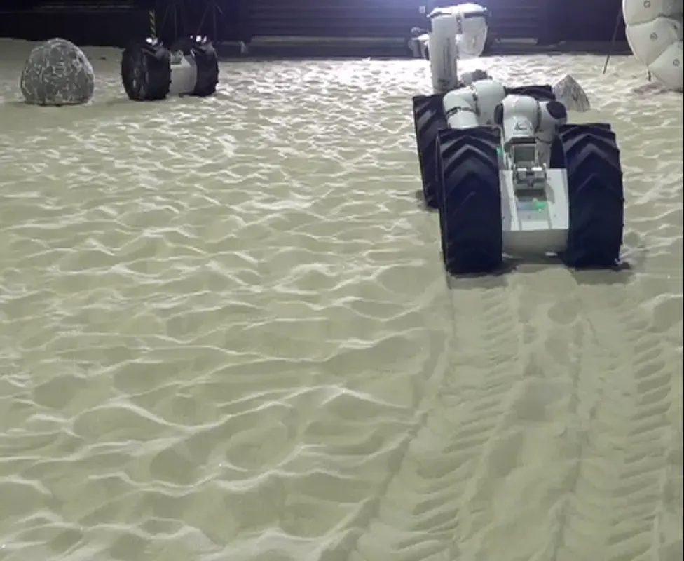 From the award-winning paper's field trial: MoonBot driving to its target under learned locomotion and steering policies, JAXA Space Exploration Test Field.