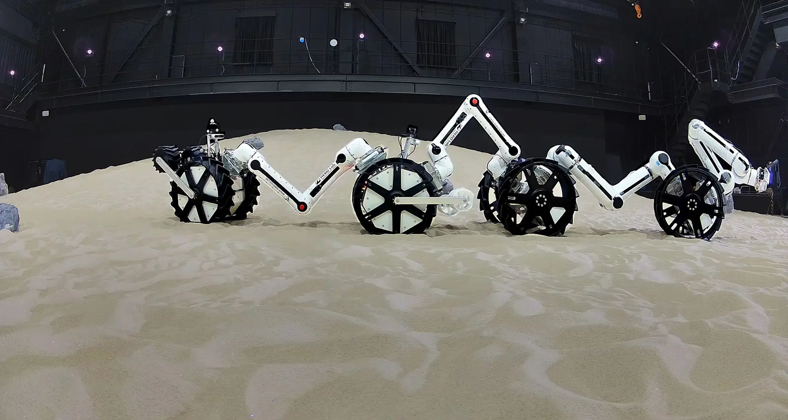 A Dragon x4 chain of eight MoonBot limb and wheel modules crossing the dune at the JAXA Space Exploration Test Field, July 2025.