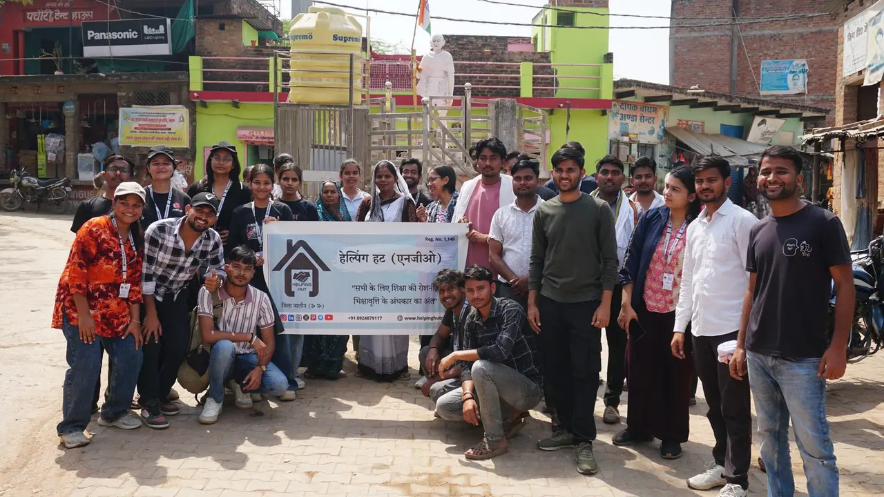 The GramSutr volunteer team on Gopalpura's main street, holding the Helping Hut banner.